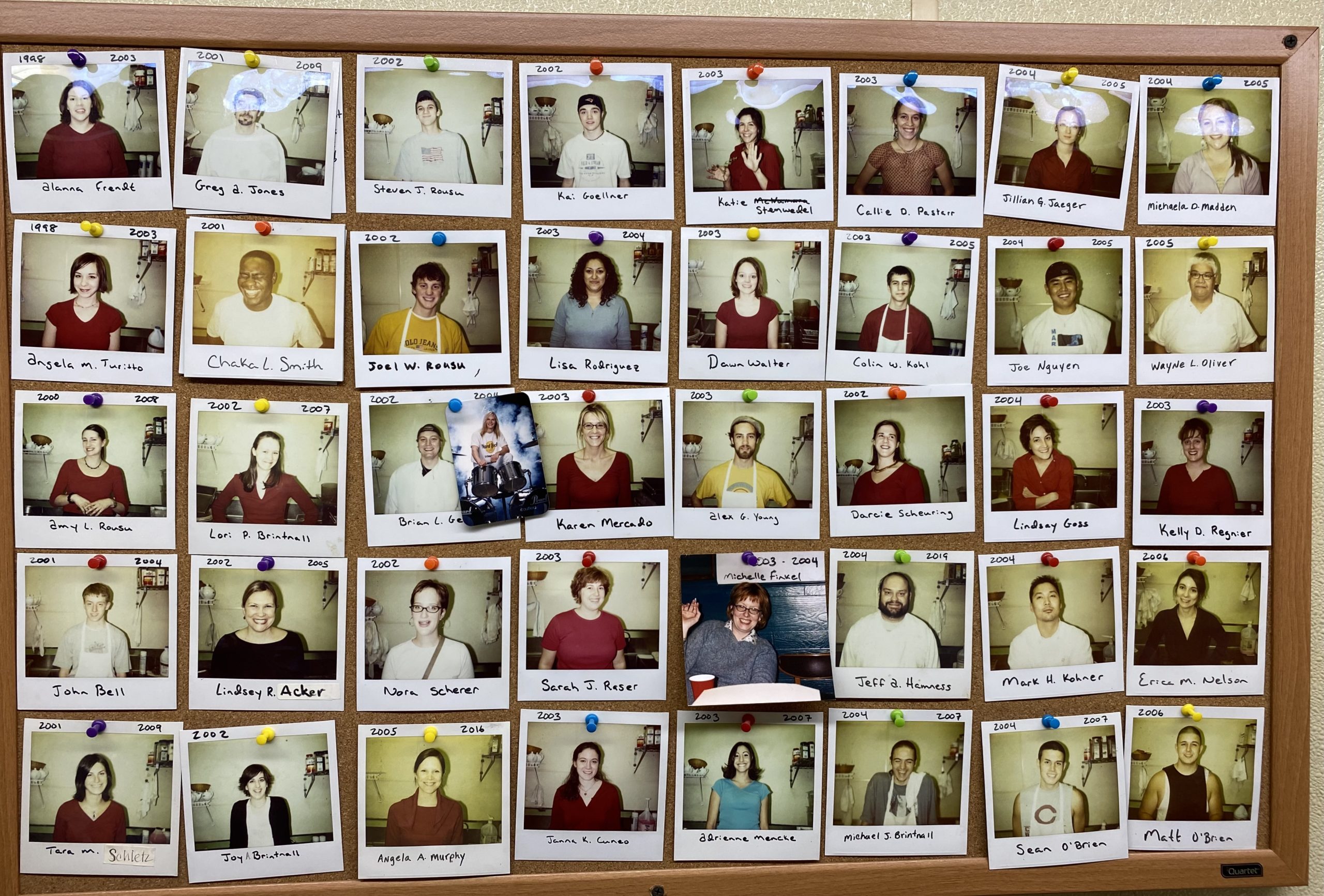 Wall of employee polaroid photographs